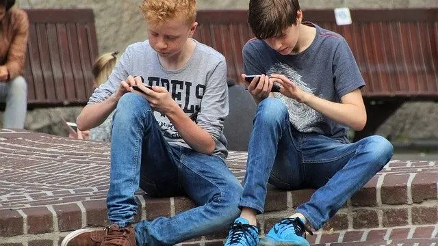 スマホゲームしている少年2人